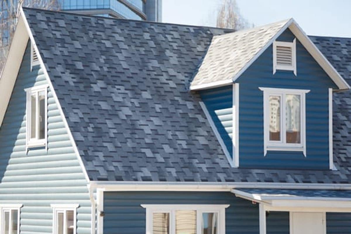 Blue and white lap siding with a shingle roof on a well-maintained Kansas home