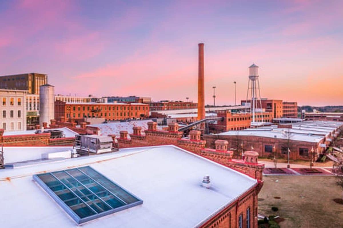 Industrial commercial rooftop with a white membrane roofing system at sunset