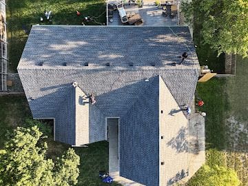 Drone view of a Global Roofing and Construction crew installing new shingles on a Kansas home