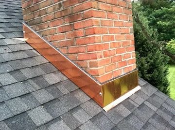 Custom copper chimney flashing fabricated and installed on a shingle roof
