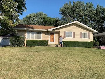 Completed roof replacement on a Kansas ranch-style home with fresh trim and shutters