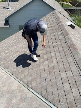 Global Roofing and Construction inspector checking shingle condition during a free roof inspection