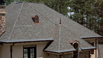 Designer shingle roof with copper chimney cap and turret accents